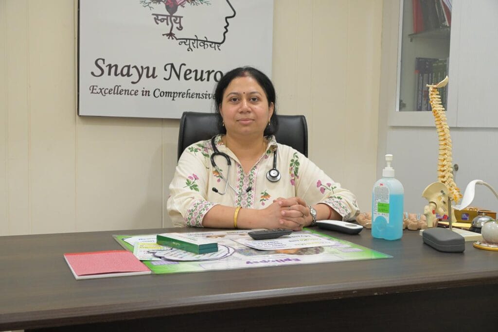 Dr. Garima Pandey seated at consultation desk inside Snayu Neurocare clinic