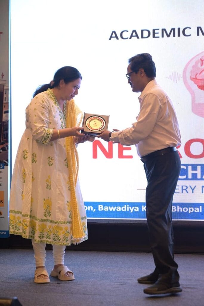 Dr. Garima Pandey receiving neurology excellence award on stage