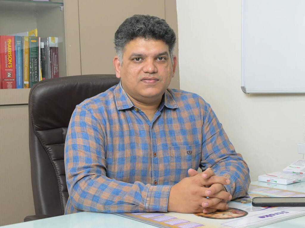 Dr. Nishant Kumar Shukla neurosurgeon sitting on a chair inside his consultation room