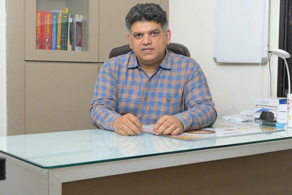 Dr. Nishant Kumar Shukla neurosurgeon sitting in his consultation clinic in Bhopal